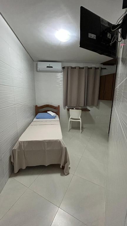 a small room with a bed and a tv at Paraíso Olindense in Olinda