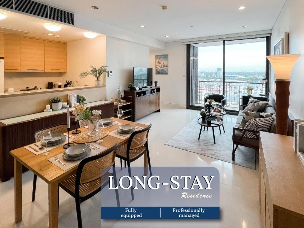 a large kitchen and living room with a long dining table at Expansive Luxury 2BR - Ultra Fast Wifi - Phrom Phong in Bangkok