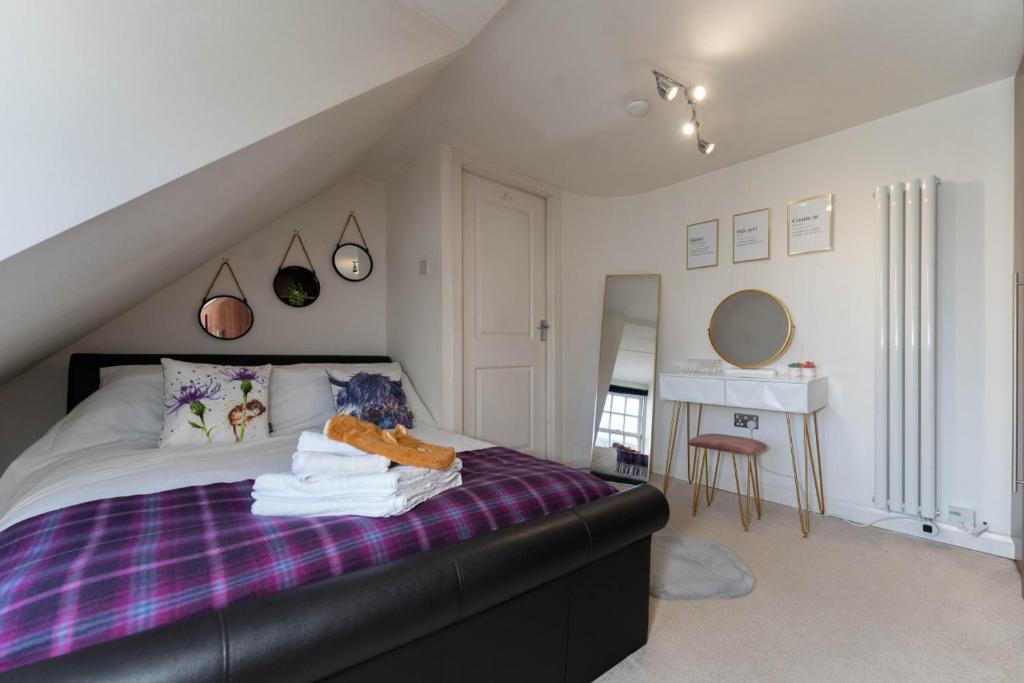 a bedroom with a bed with a purple blanket at Perth Penthouse at the Concert Hall in Perth