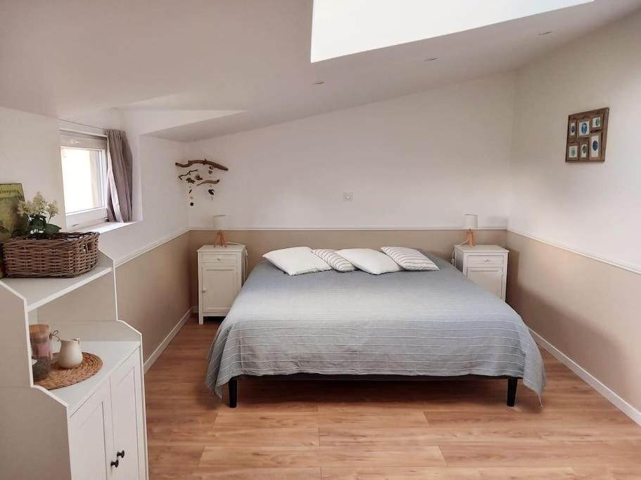 una camera da letto con un letto con due cuscini sopra di La petite maison dans la prairie a Lamballe Armor