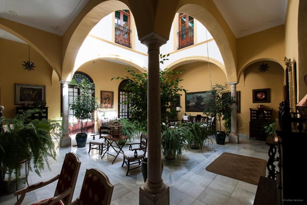 una habitación con sillas y plantas en un edificio en Casa San José, en Palma del Río
