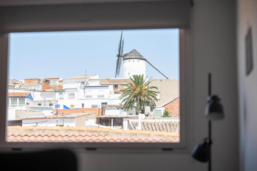 a window view of a city with a windmill at Ático céntrico con vistas a Los Molinos in Campo de Criptana