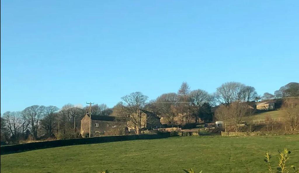 a green field with a house in the distance at Hob Lane Farm Cottage - Peak Park in Oughtibridge
