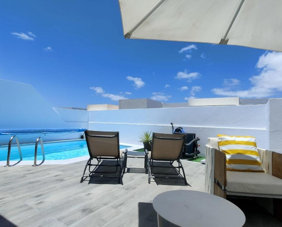a patio with chairs and a table and the ocean at Goikiri in Playa Blanca