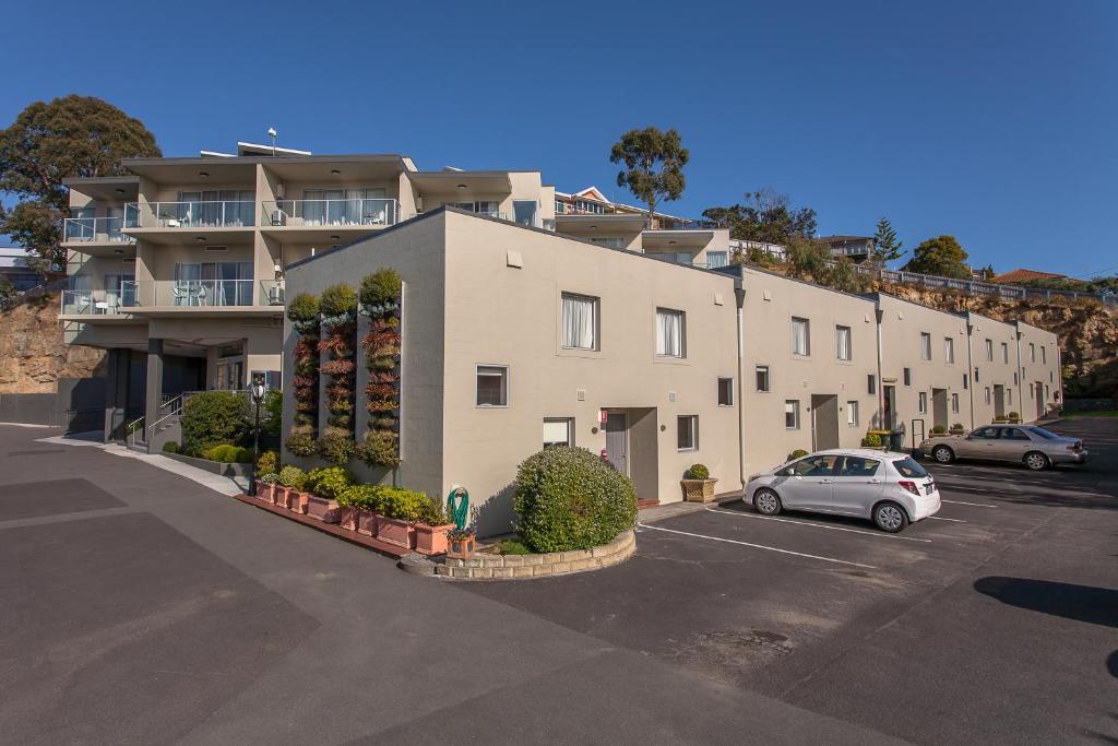 a large building with a car parked in a parking lot at Bay View Villas in Hobart