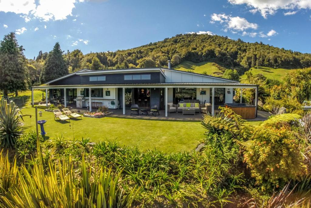 an image of a house with a hill in the background at City Lights Boutique Lodge in Rotorua