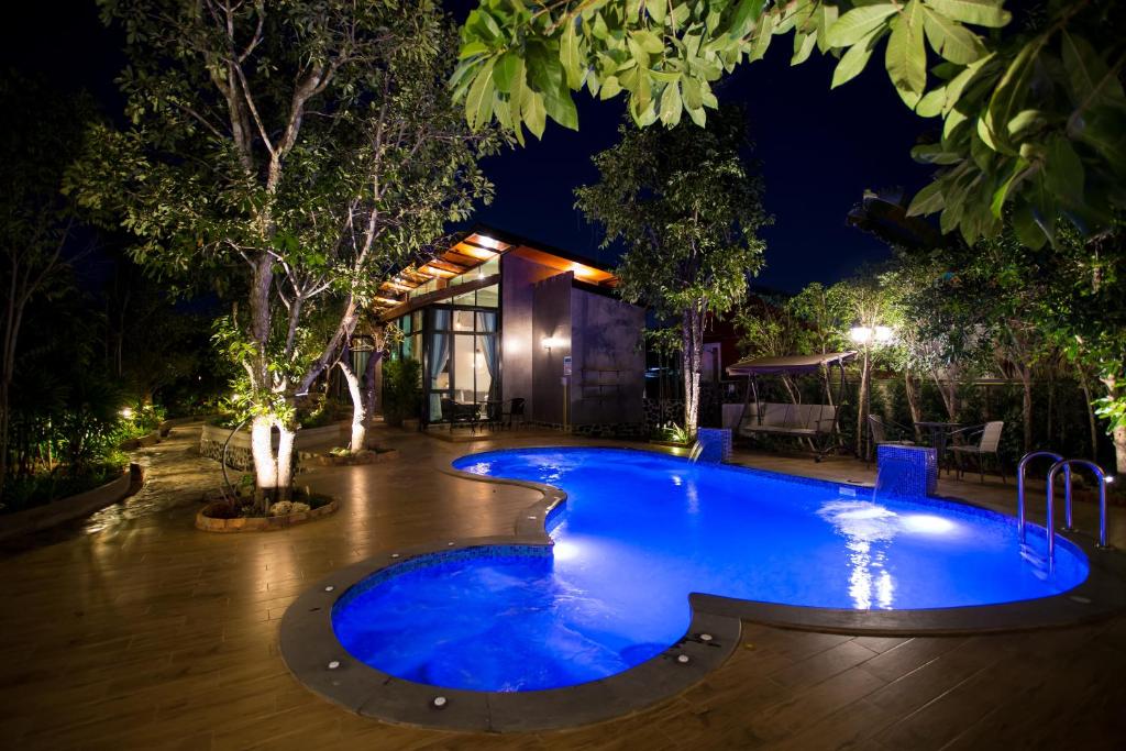 a swimming pool in a resort at night at Foresto Sukhothai Guesthome in Sukhothai