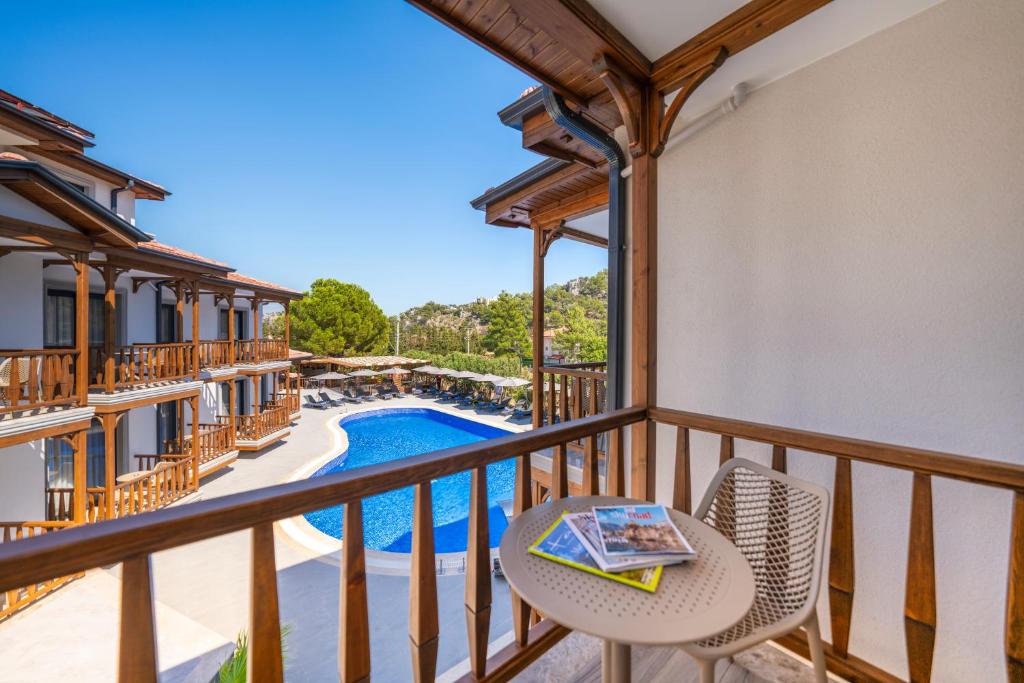 Un balcón con mesa y sillas y una piscina. en Marvelous Sarıgerme, en Sarigerme