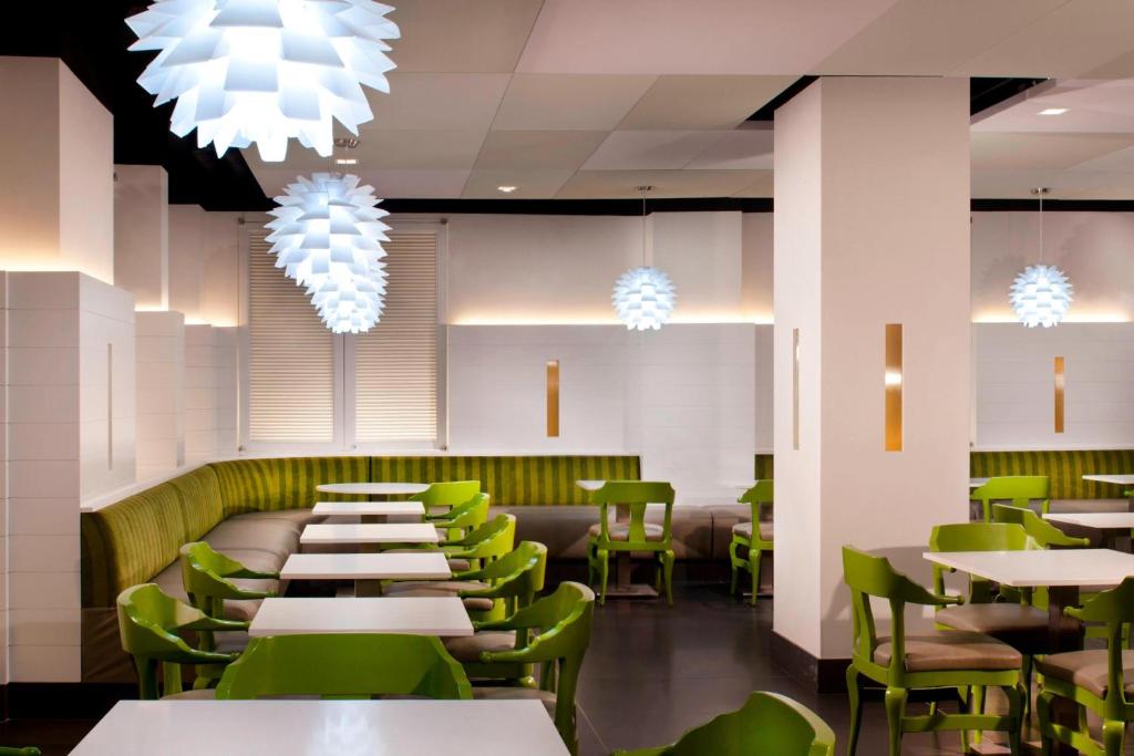 a restaurant with white tables and green chairs at Residence Inn by Marriott New York Downtown Manhattan/World Trade Center Area in New York