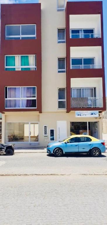 a blue car parked in front of a building at Apartamento Rua do museu dos Náufragos in Sal Rei