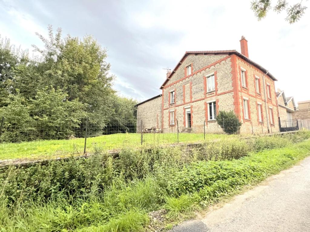 an old brick building on the side of a road at La Usine du Charme in Saint-Menges