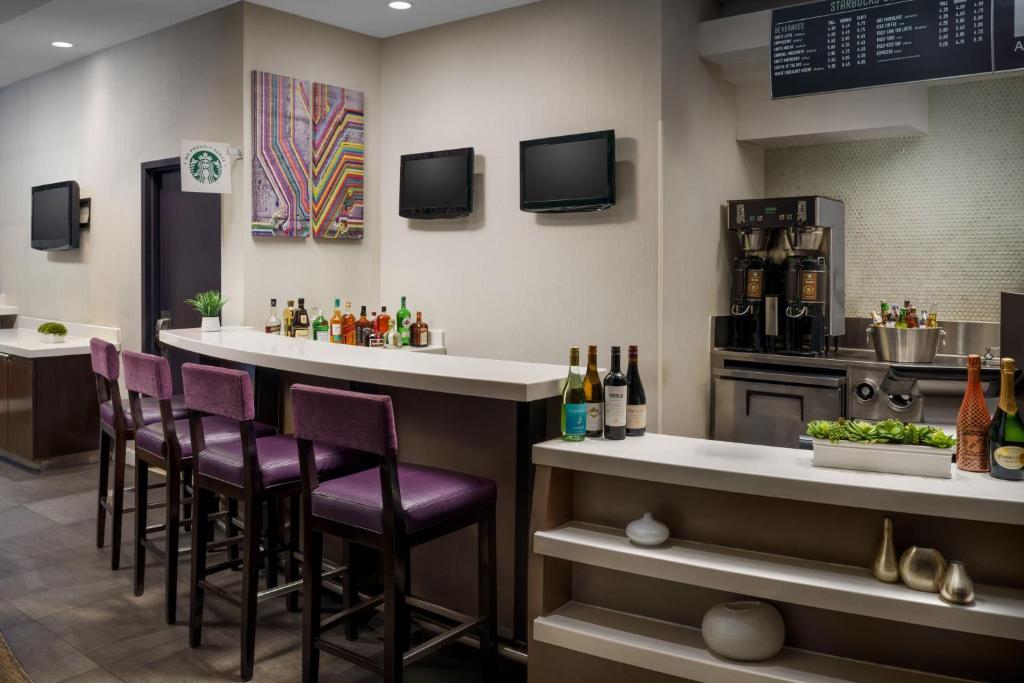 a bar in a restaurant with purple stools at Courtyard New York Manhattan/Times Square in New York