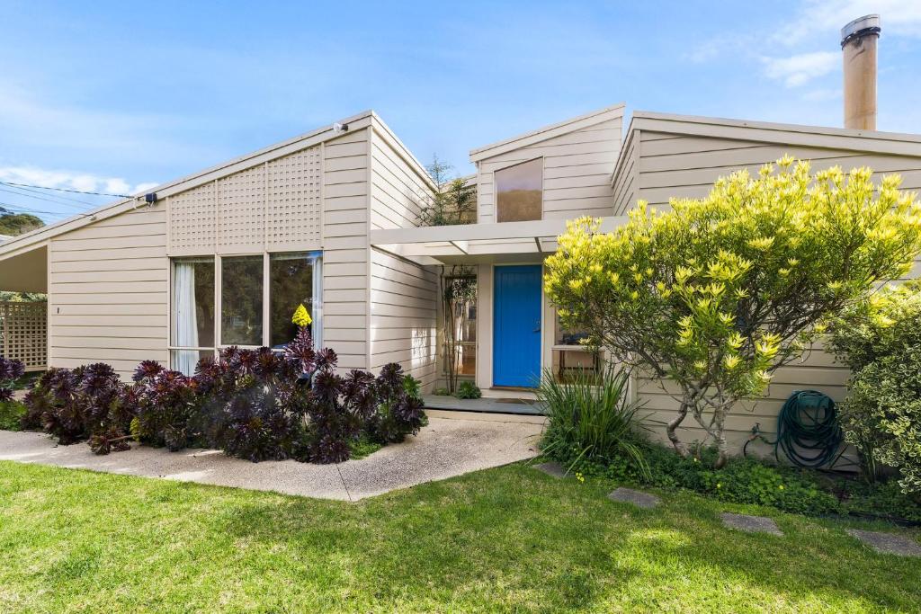 una casa blanca con una puerta azul en Lonsdale Back Beach Retreat, en Point Lonsdale