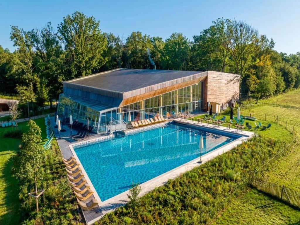 een luchtfoto van een gebouw met een zwembad bij Belvilla Treehouse in woods in Antoing