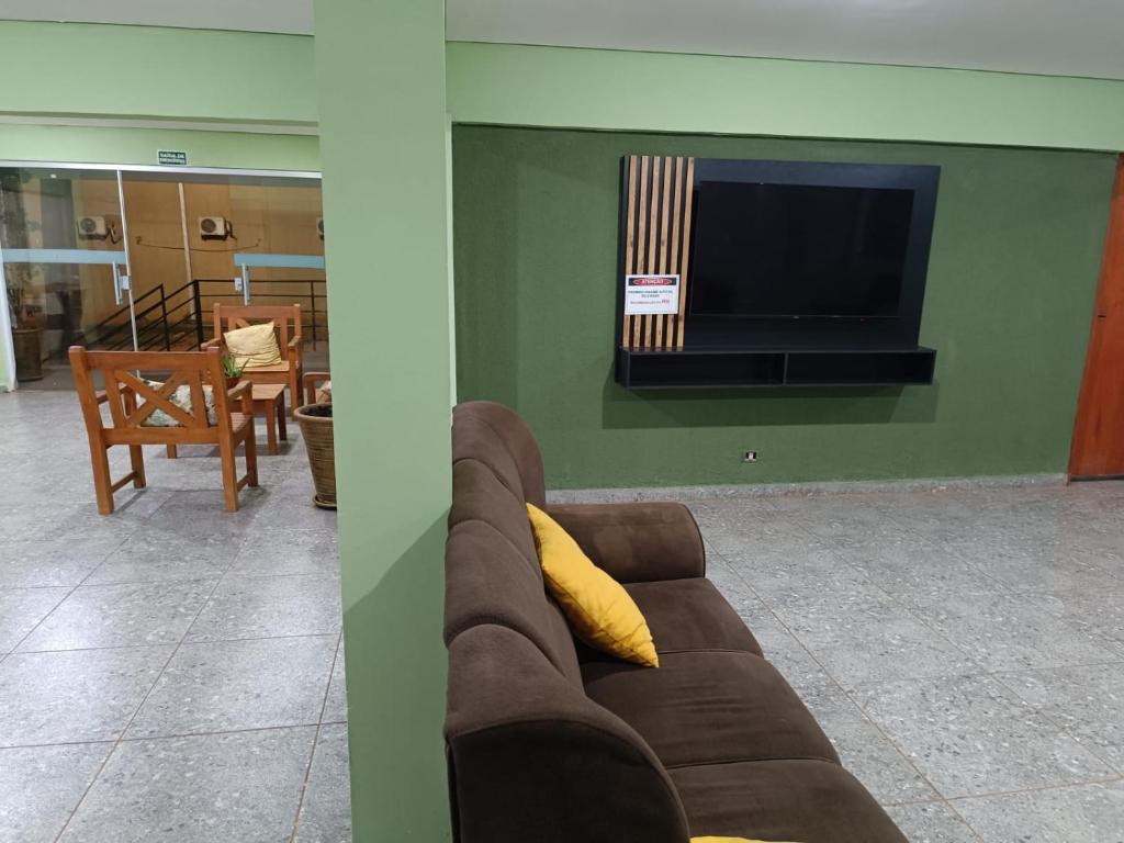 un soggiorno con divano e TV a schermo piatto di Hotel Cerrado Palace a Ribas do Rio Pardo