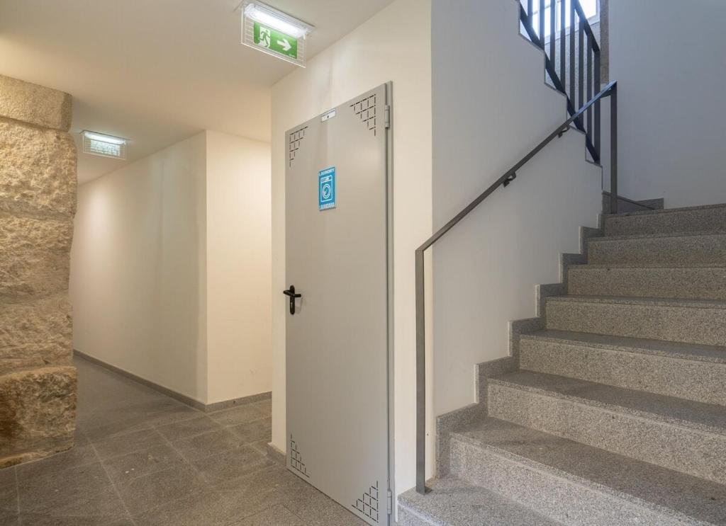 a hallway with stairs and a door in a building at Habitatio - Foz by LuxiStay in Porto