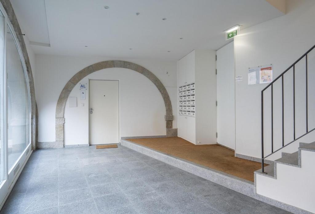 an empty hallway with an archway and a white door at Habitatio - Foz by LuxiStay in Porto