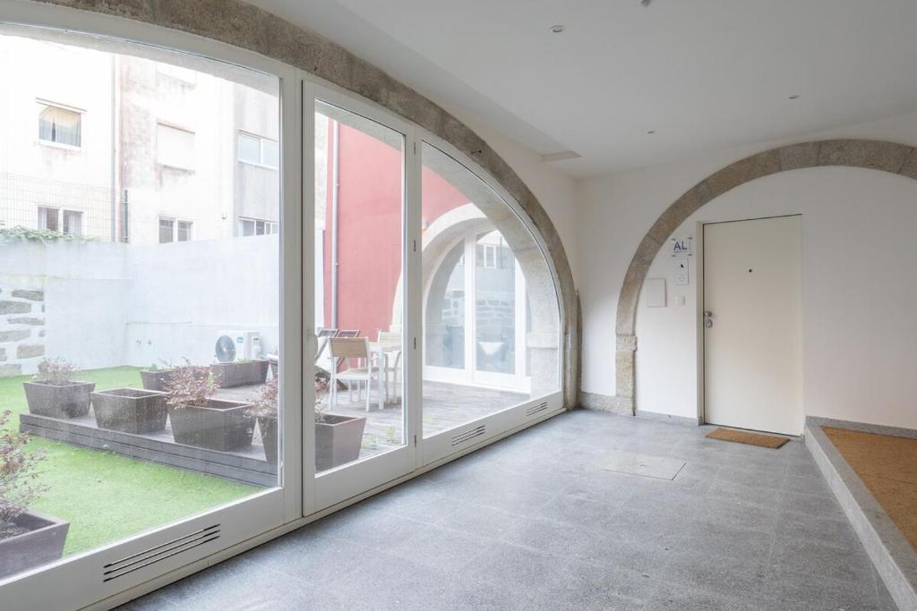 an empty room with large windows and a door at Habitatio - Foz by LuxiStay in Porto