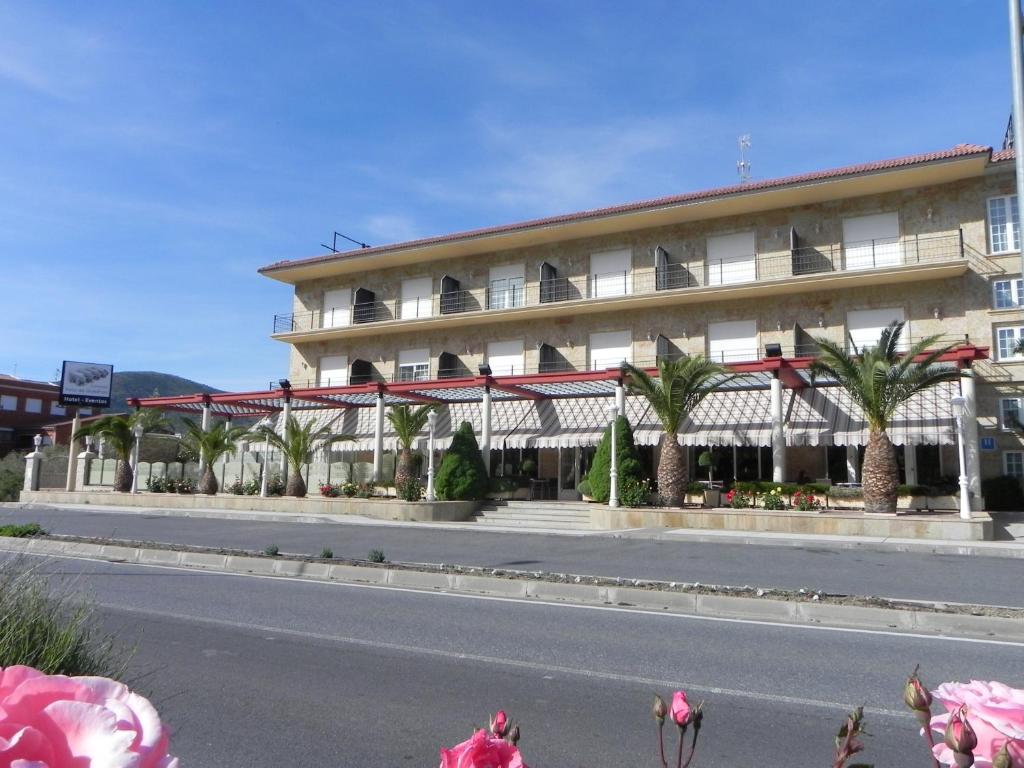 a building with palm trees in front of a street at Toros de Guisando in El Tiemblo