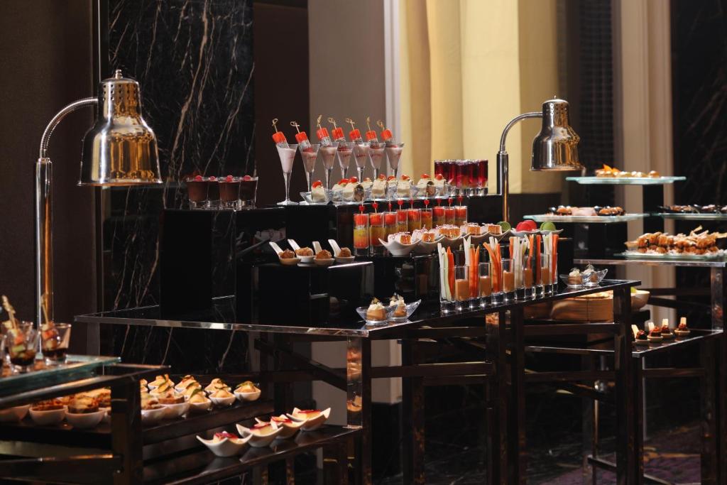 A dessert and pastry buffet arranged on tiered black display tables.