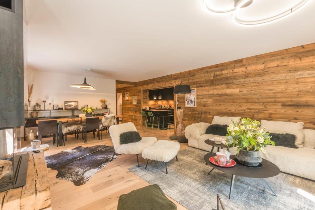 - un salon avec un mur en bois dans l'établissement Appartement Capra - Welkeys, à Megève