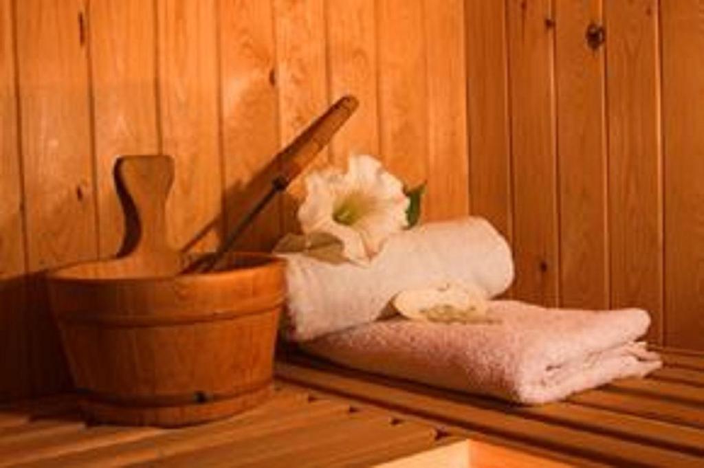 a wooden mortar and pestle next to a towel and a wooden bucket at Sauna Apartament in Braşov