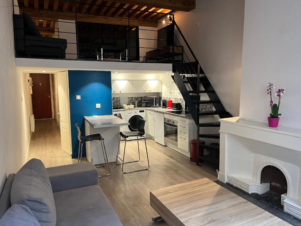 un salon avec une cuisine et un escalier dans l'établissement T2 avec mezzanine, à Fourvière