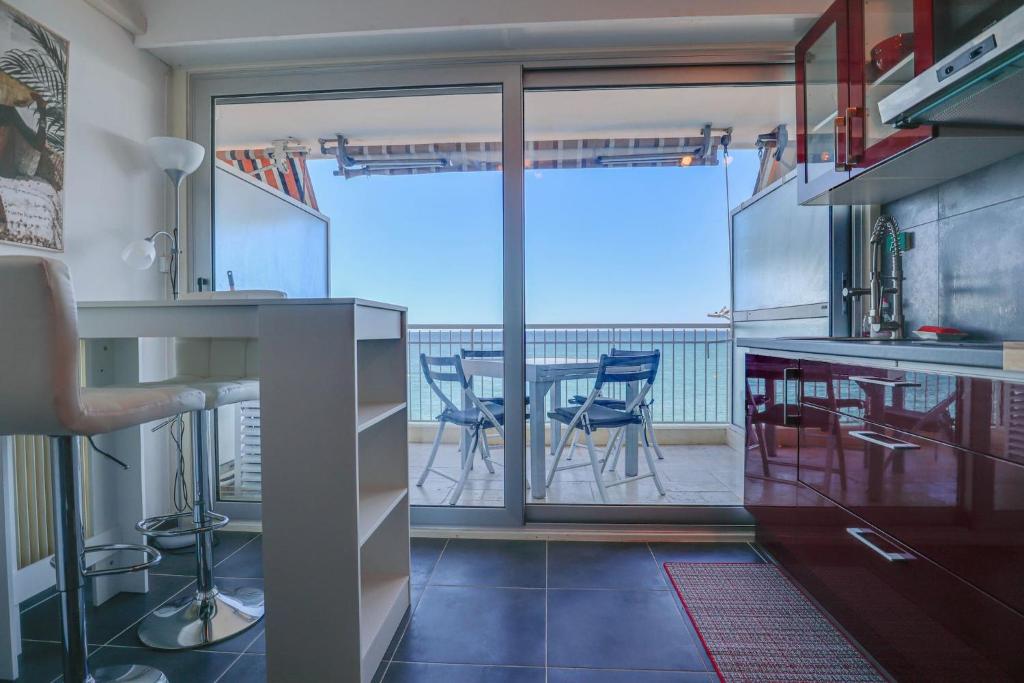 - une cuisine avec vue sur une table et des chaises dans l'établissement « Château Saint Louis 3 » Vue Mer, Terrasse, à Menton