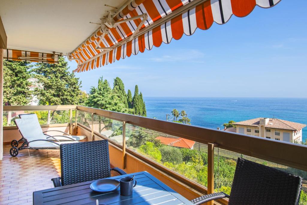 balkon ze stołem i krzesłami oraz oceanem w obiekcie "La Cuse" Vue Mer Imprenable, Calme, Parking w Mentonie