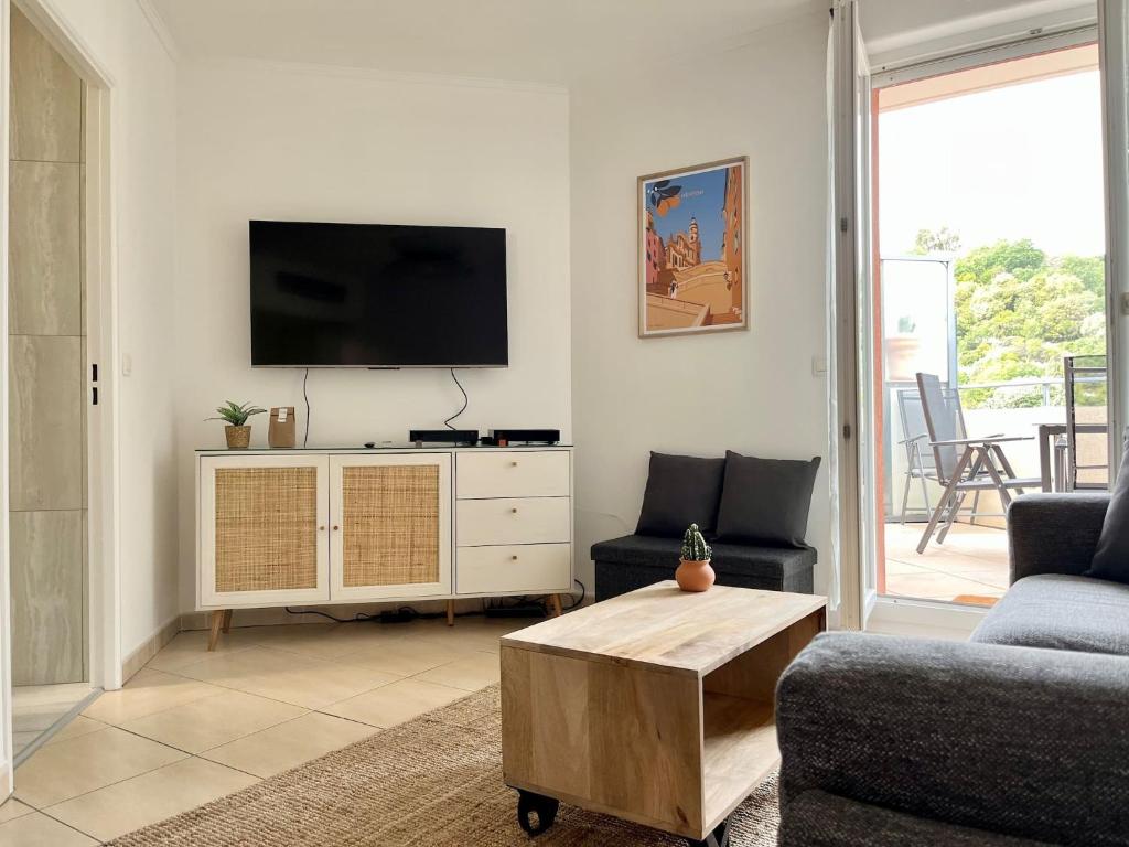 un salon avec une télévision à écran plat sur un mur dans l'établissement 'La Villa Melanie' Neuf, Equipé, Terrasse, Centre, à Menton