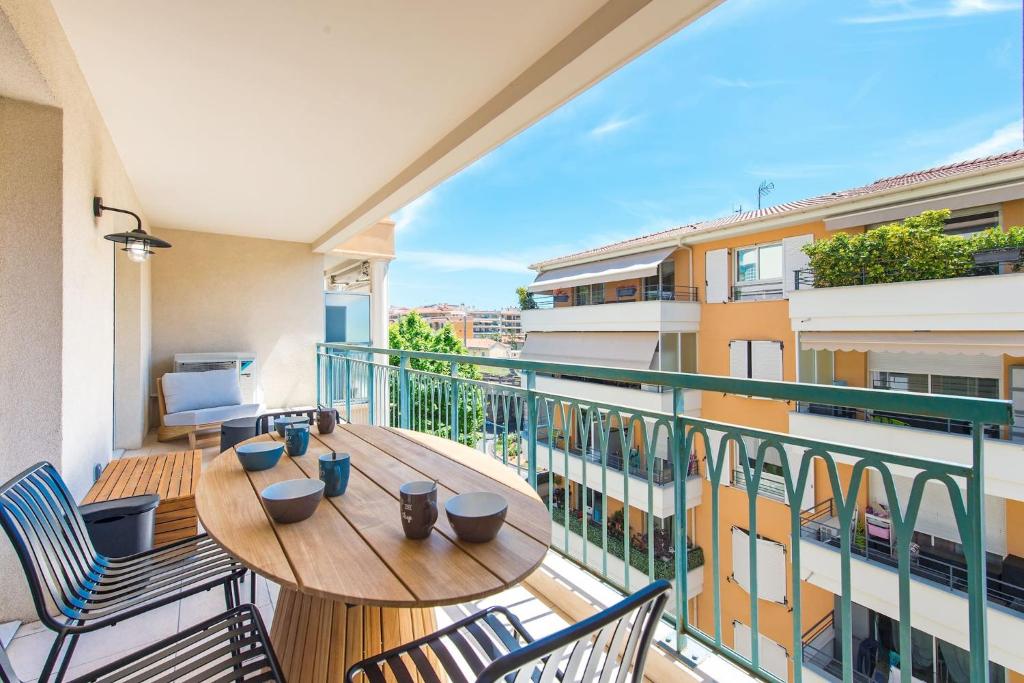 d'un balcon avec une table et des chaises en bois. dans l'établissement Altezza, parking proche gare, à Menton