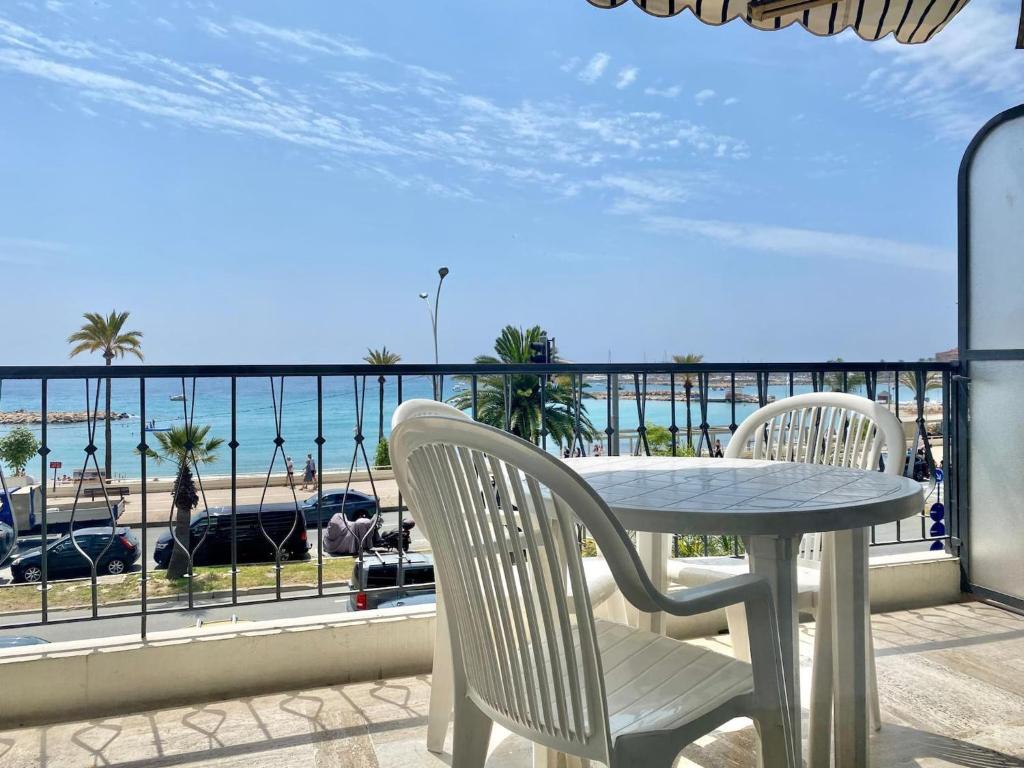 une table et des chaises sur un balcon avec vue sur la plage dans l'établissement Le mona lisa, vue mer, balcon, à Menton