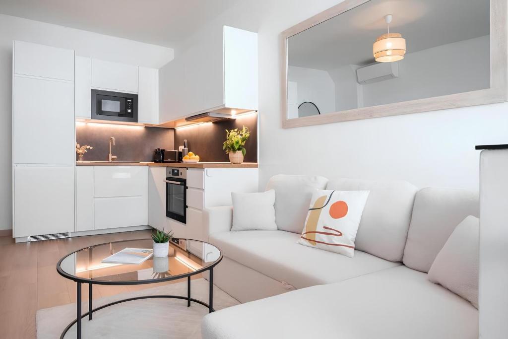 un salon avec un canapé blanc et une table en verre dans l'établissement Cozy appartement Plein Centre, Proche Gare/plage, à Menton