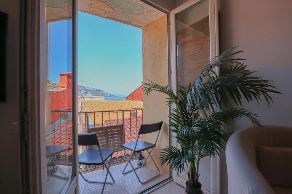 Cette chambre dispose de chaises et d'un balcon avec vue. dans l'établissement 'La Belle Vue Mer' Cozy Appartement, Centre, Plage, à Menton