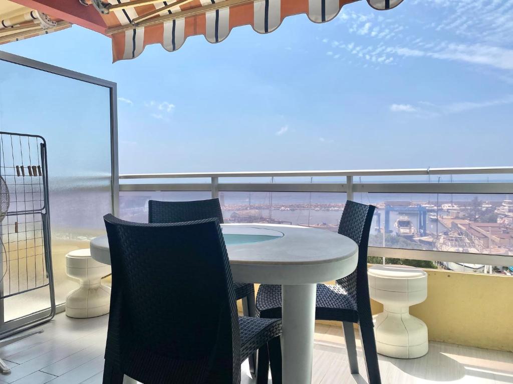 une table et des chaises sur un balcon avec vue dans l'établissement Le diplomat, vue mer, cosy, à Menton