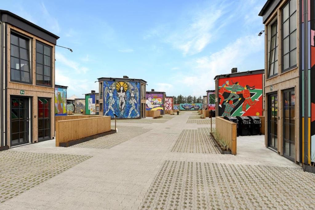 a street with paintings on the sides of buildings at Rent A Holiday Home In Fun Art Fun In Blokhus! in Pandrup