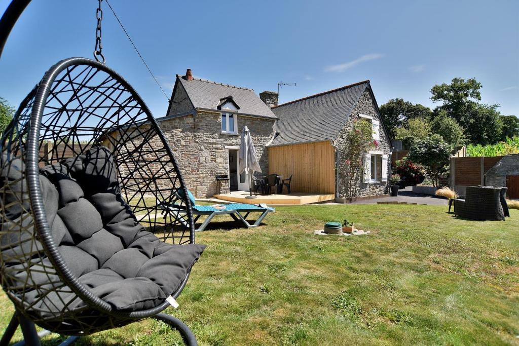 a swing in a yard in front of a house at La Campagne Émeraude - Proche du Mont Saint-Michel in Baguer-Morvan
