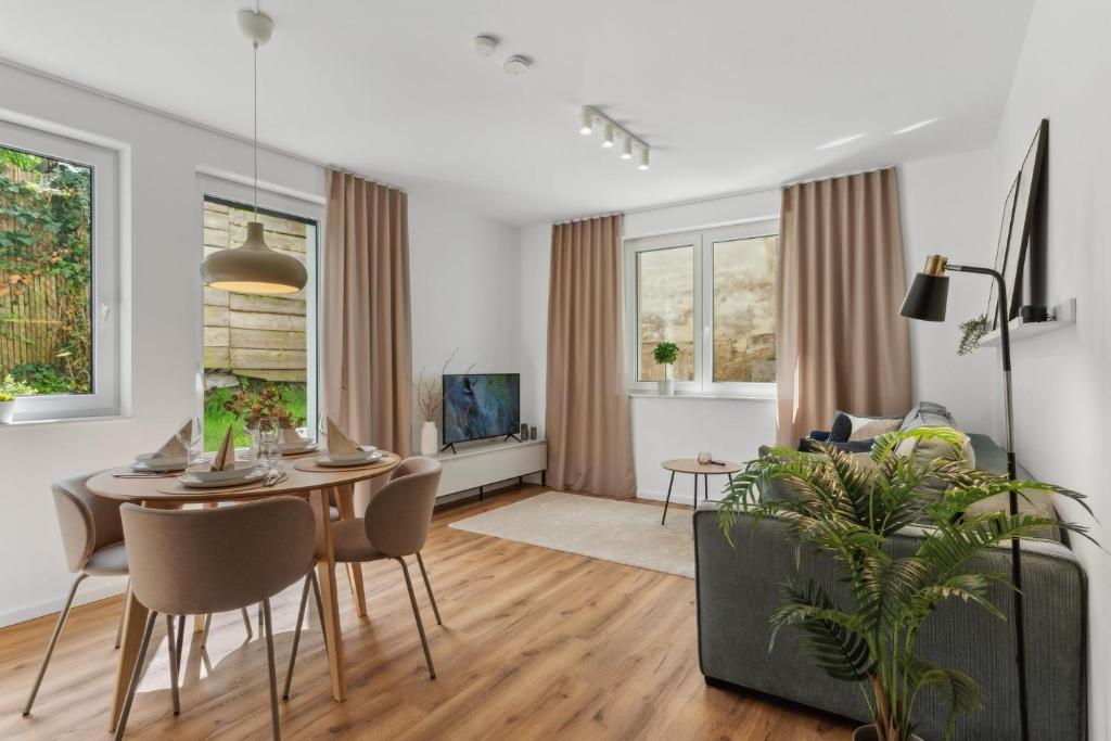 a living room with a table and a couch at Modernes Apartment Bielefeld Zentrum,Parkplatz, Terrasse & kontaktloser Check-in in Bielefeld