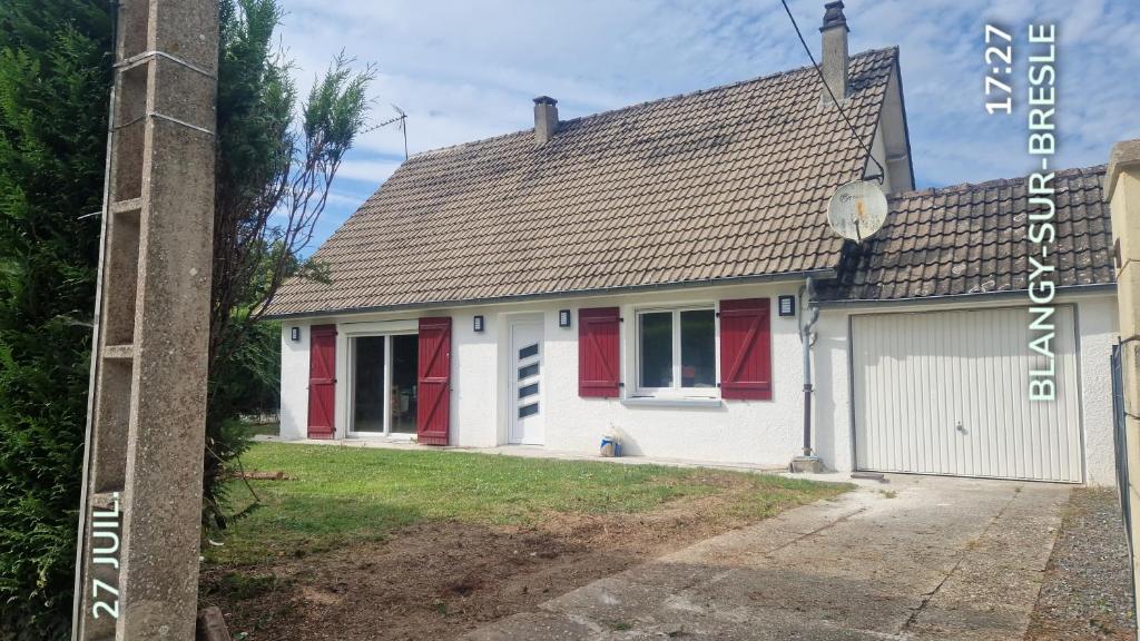 une maison blanche avec des portes rouges et un garage dans l'établissement La désirée, à Blangy-sur-Bresle