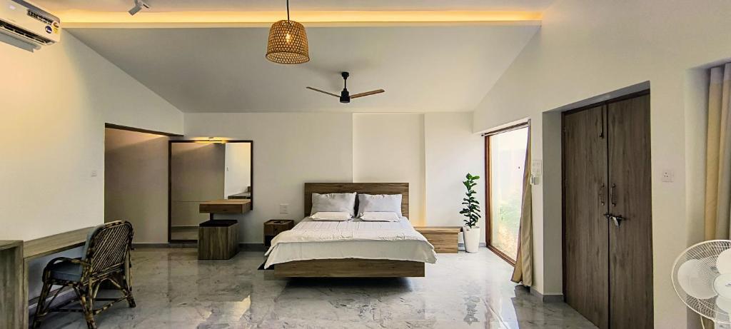 una camera da letto con un letto e una grande finestra di Vayu Villa By The Sea a Canacona
