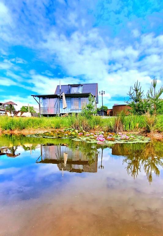 a house is reflected in a body of water at DAGNA summer house in Šunupis