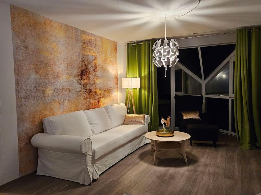 a living room with a white couch and a table at Ferienwohnung mit Weinbergblick in Radebeul