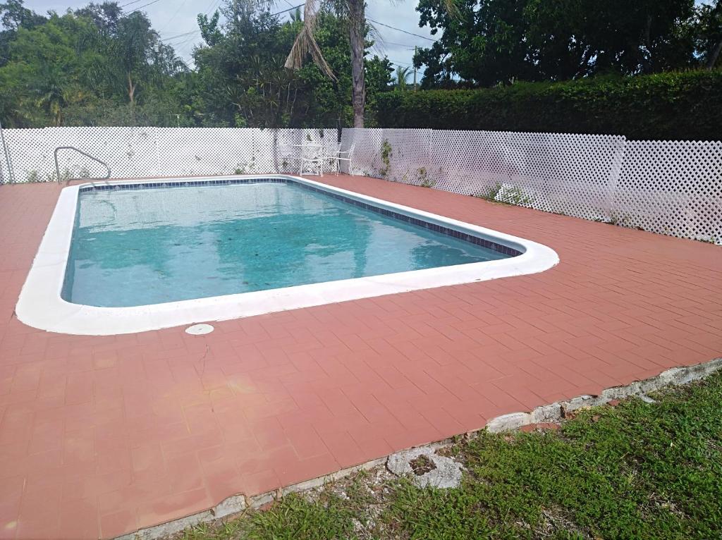 a swimming pool with a red tile floor and a fence at Cozy apartment in quite zone in Hollywood