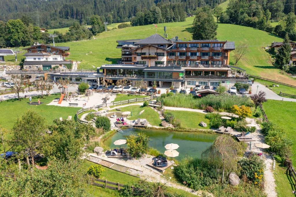 a large hotel on top of a hill with a lake at Hotel Penzinghof in Oberndorf in Tirol
