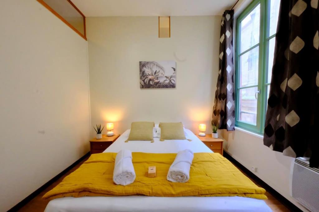 a bedroom with a bed with yellow sheets and a window at Rouen Saint Romain - Chez Solange in Rouen