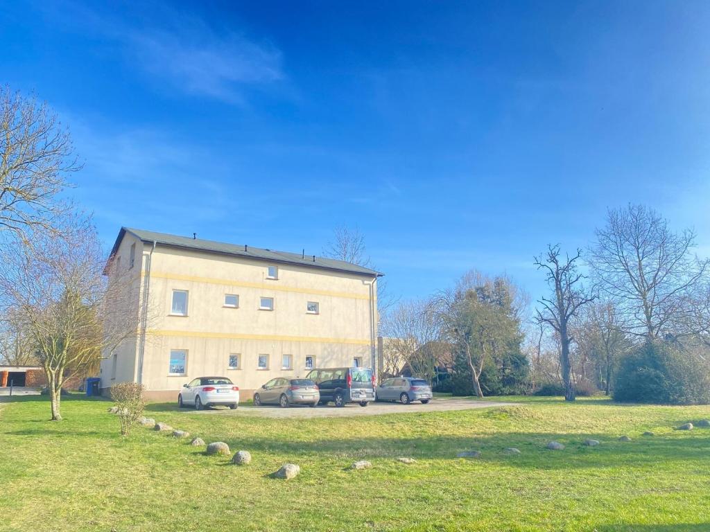 a large building with cars parked in front of it at Pension 28 - Zimmer 4-6 in Velgast