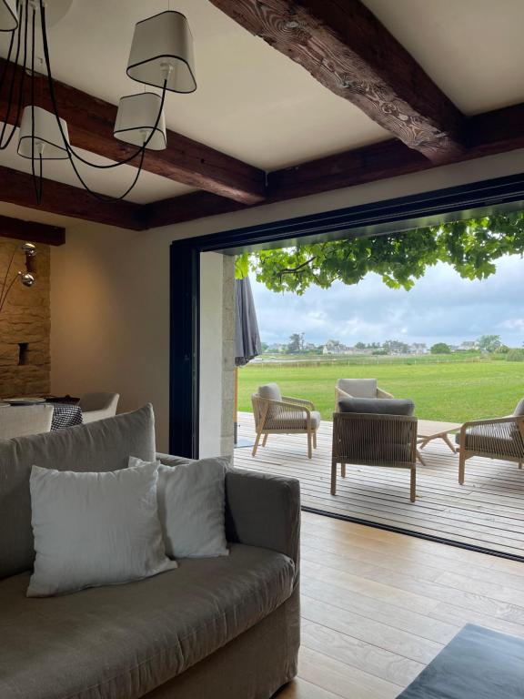 a living room with a couch and a large sliding glass door at Villa Mamina, face à la mer, île Grande in Pleumeur-Bodou