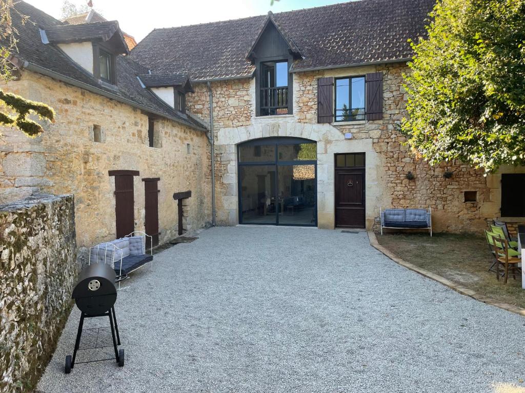a grill on a tripod in front of a building at La Callibetière in Tourtoirac
