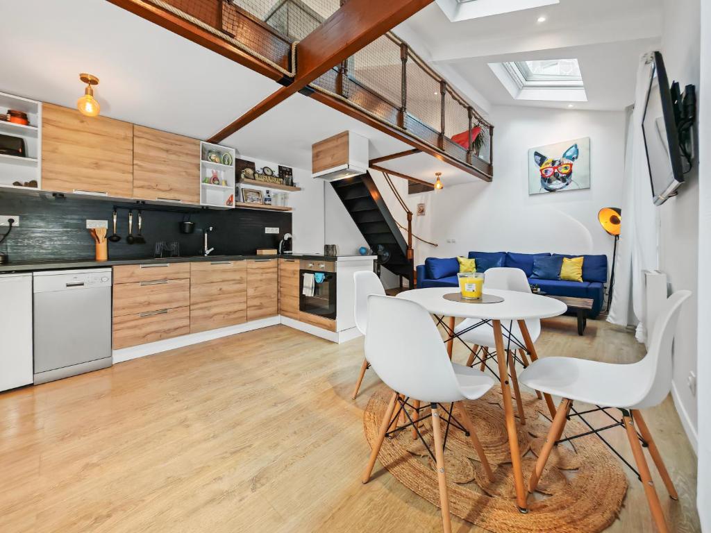 Una cocina y un comedor con mesa y sillas. en Loft Duplex à 2 min de Paris - Parking gratuit, en Le Pré-Saint-Gervais