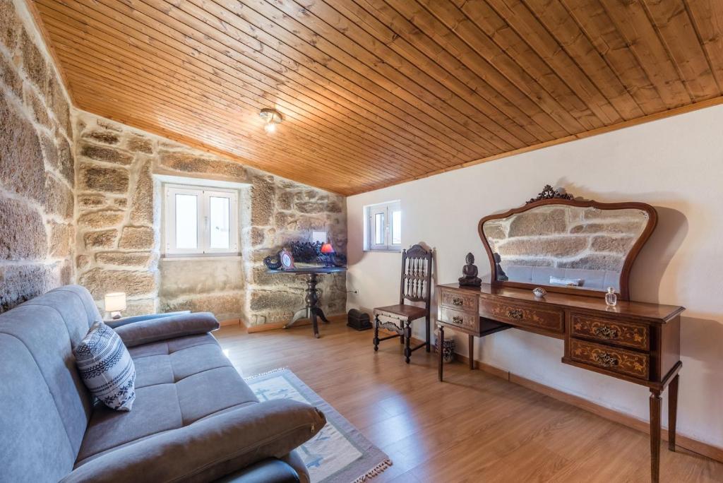 a living room with a couch and a wooden ceiling at Stone House in the Peneda-Gerês National Park in Montalegre
